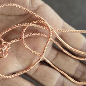 Puede incluir: Un collar de cadena de oro rosa con un dise&ntilde;o delicado y trenzado. La cadena est&aacute; hecha de un metal liso y brillante y tiene un cierre de langosta.