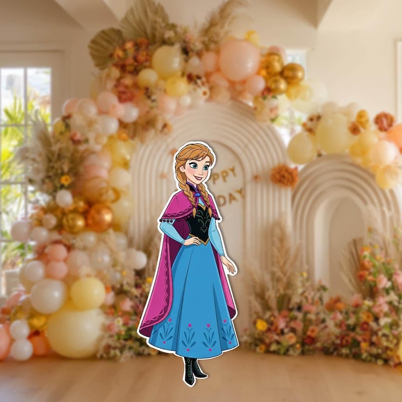 May include: A cutout of a cartoon character in a blue dress with a pink cape. The character has blonde hair in braids and is standing in front of a decorative arch with balloons and flowers. The arch has the words "Happy Day".