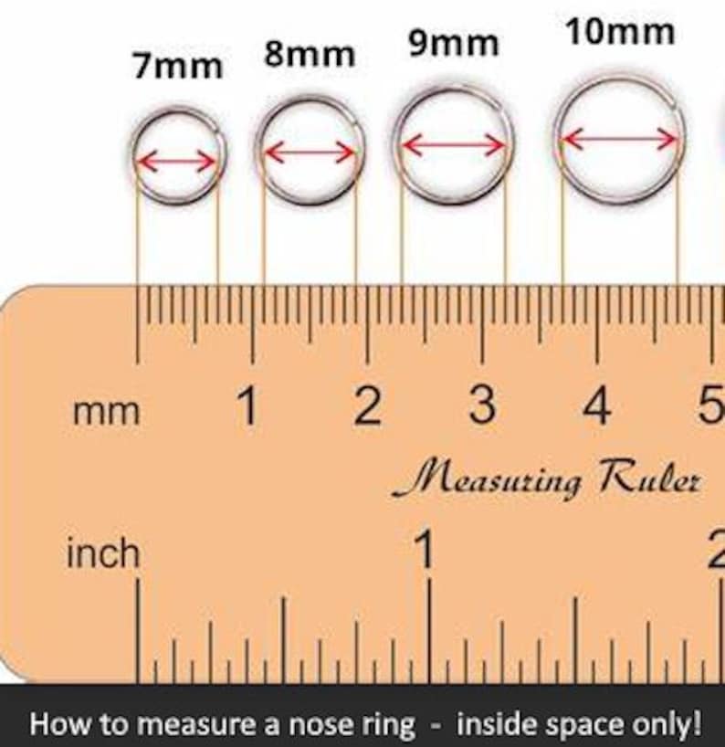 May include: Four silver-toned circular nose rings arranged in a row above a wooden ruler. The rings are labeled 7mm, 8mm, 9mm, and 10mm, with red arrows indicating the inside diameter. The ruler shows both millimeter and inch markings.