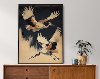 May include: A framed print of two cranes in flight against a dark background. The cranes are depicted in a traditional Japanese style with intricate details and vibrant colors.