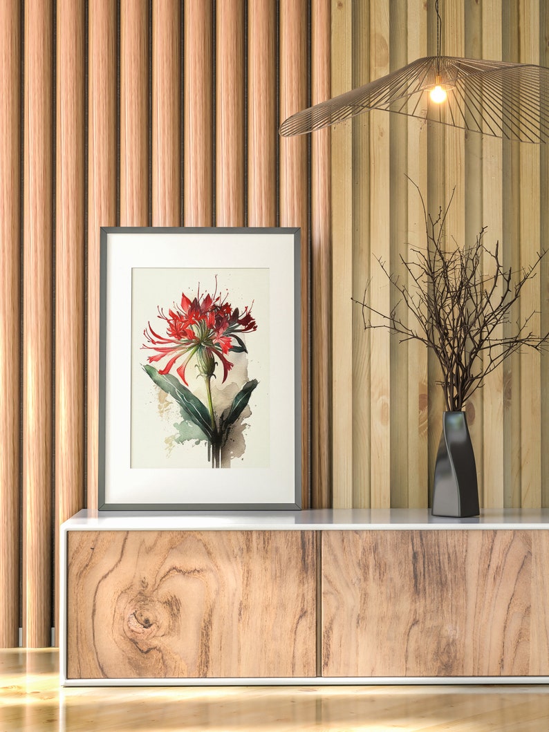 Puede incluir: Una impresi&oacute;n enmarcada de una flor roja con hojas verdes sobre un fondo blanco. La impresi&oacute;n est&aacute; colgada en una pared con paneles de madera. Un jarr&oacute;n negro con una rama seca est&aacute; sobre un gabinete de madera con dos cajones.