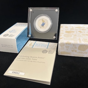 Puede incluir: Una moneda Peter Rabbit 2017 UK 50p Silver Proof, exhibida en una funda protectora transparente. La moneda presenta una colorida ilustración de Peter Rabbit. Se incluyen un certificado de autenticidad y una caja decorativa.