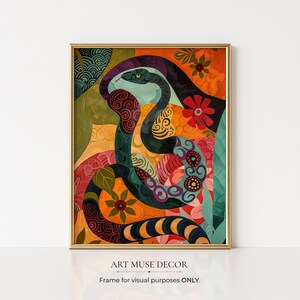 May include: A framed art print featuring a colorful snake illustration. The snake is depicted with intricate patterns in shades of teal, orange, and black, set against a floral and leaf-filled background. The artwork is framed in a gold-colored frame. The text "ART MUSE DECOR" is at the bottom.