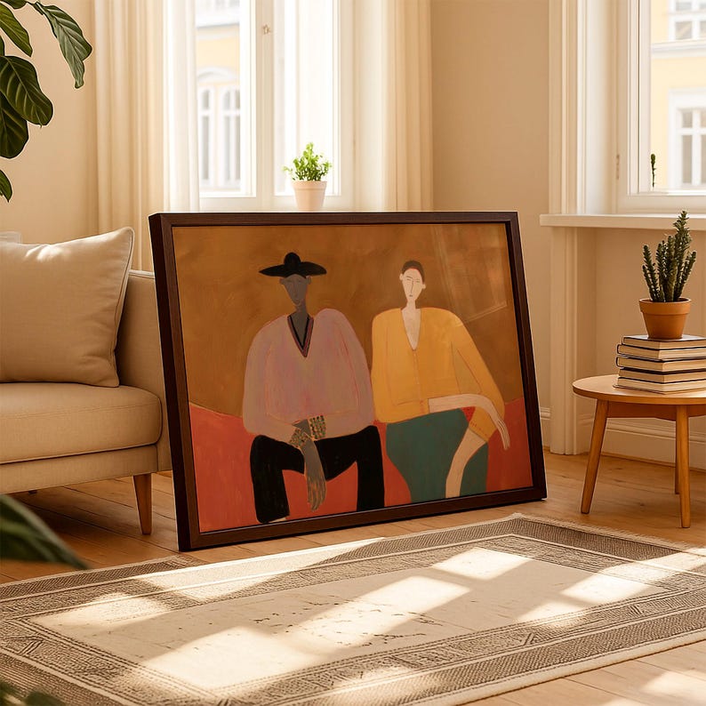 May include: A framed horizontal wall art print featuring a stylized illustration of two figures sitting side by side. The figure on the left wears a black hat and light pink shirt, while the figure on the right wears a yellow shirt and teal pants.