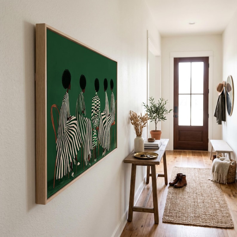 May include: A framed art print featuring a green background with a line of figures in patterned clothing. The figures are depicted from the back, with black hair and various black and white striped and checkered patterns. The frame is a light wood color.