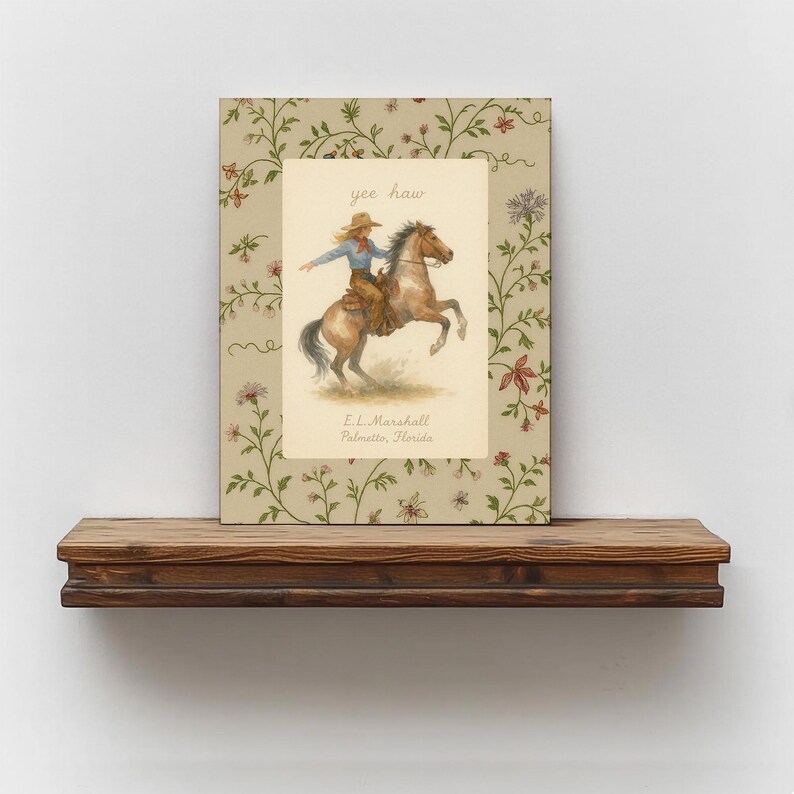 Puede incluir: Una impresi&oacute;n rectangular con una ilustraci&oacute;n central de una persona montando un caballo marr&oacute;n encabritado, con el texto yee haw y E.L. Marshall Palmetto, Florida. El borde muestra un fondo beige con un patr&oacute;n de enredaderas y flores.
