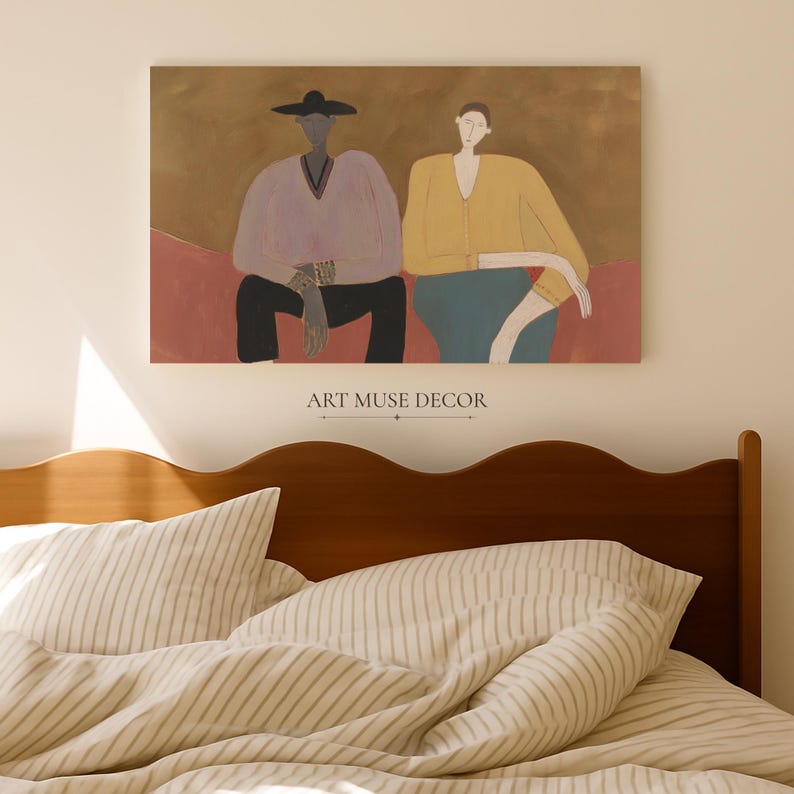 May include: A rectangular wall art print featuring two figures sitting side-by-side against a brown background. The left figure wears a wide-brimmed hat, a light purple V-neck top, and black trousers. The right figure wears a yellow long-sleeved top and a teal skirt.