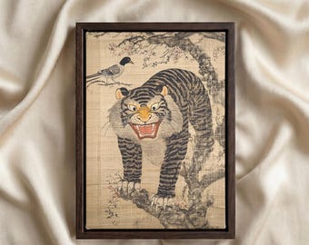 May include: A rectangular framed wall art piece featuring a tiger with black stripes and an open mouth standing on a tree branch. A small bird is perched on a branch above the tiger. The artwork is set within a dark brown wooden frame.