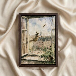 May include: A framed oil painting depicting a view through an open window overlooking a city skyline. A figure on a broomstick flies across a cloudy sky. A potted plant sits on the windowsill in the foreground. The frame is dark brown wood.