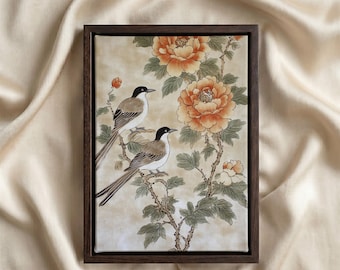 Può includere: Un'opera d'arte da parete rettangolare incorniciata raffigurante due uccelli con testa nera e corpo marrone appollaiati su un ramo con grandi peonie arancioni e foglie verdi, su uno sfondo color beige chiaro.
