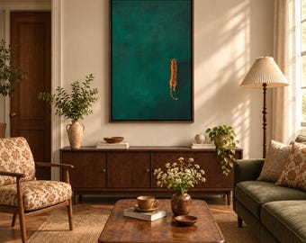 May include: A rectangular wall art piece featuring a deep teal background with a small, orange, spotted tiger illustration positioned on the right side. The artwork is enclosed in a dark brown wooden frame and hangs above a wooden sideboard.