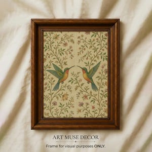 May include: A framed print featuring two hummingbirds facing each other, set against a floral background. The birds have green, orange, and blue plumage. The frame is a dark brown color. Text at the bottom reads "ART MUSE DECOR" and "Frame for visual purposes ONLY."
