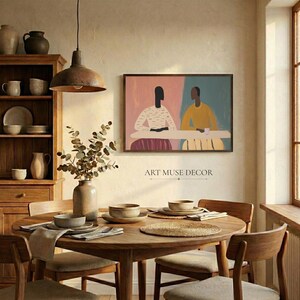 Pu&ograve; includere: Una sala da pranzo con un tavolo rotondo in legno apparecchiato con piatti, ciotole e tovagliette. Un'opera d'arte incorniciata raffigurante due figure sedute a un tavolo &egrave; appesa alla parete. Il testo "ART MUSE DECOR" &egrave; sotto.