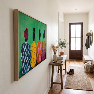 May include: A framed artwork featuring a green background with five figures in colorful patterned clothing. The figures are depicted from the back, with a variety of patterns including polka dots, stripes, and a checkered design. The frame is made of light-colored wood.