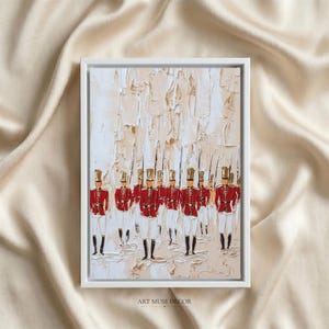 May include: A framed oil painting featuring a group of soldiers in red uniforms with tall hats, rendered in a thick impasto technique. The background consists of textured, neutral cream and beige paint strokes, creating a layered effect.