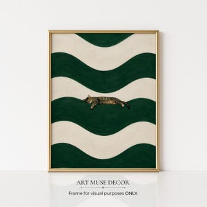 Può includere: Una stampa artistica incorniciata con un gatto tigrato che riposa su un motivo ondulato verde e crema. L'opera d'arte è esposta in una cornice dorata e include il testo "ART MUSE DECOR" e "Frame for visual purposes ONLY."
