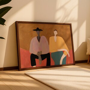 May include: A framed rectangular wall art print featuring a stylized illustration of two figures sitting side by side. The figure on the left wears a black hat, a light pink long-sleeved top, and black pants. The figure on the right wears a yellow long-sleeved top and a teal skirt, set against a warm brown and red background.