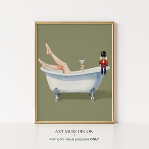 May include: A framed art print depicting a person in a clawfoot bathtub, holding a cocktail, with a toy nutcracker. The background is olive green. The print includes the text "ART MUSE DECOR" and "Frame for visual purposes ONLY."