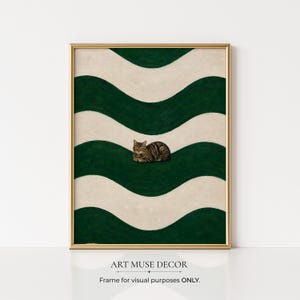 May include: A framed art print featuring a tabby cat resting on a green and cream wavy pattern. The artwork has a gold frame and the text "ART MUSE DECOR" and "Frame for visual purposes ONLY." at the bottom.