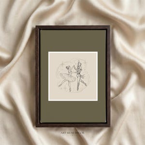 Pode incluir: Uma peça de arte de parede emoldurada com uma moldura de madeira castanho-escura e um passe-partout verde-azeitona suave. A impressão central apresenta um desenho de linha de uma bailarina e um soldado quebra-nozes a dançar, rodeados por estrelas.