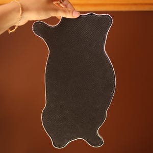 K&ouml;nnte beinhalten: Schwarze Stoff-Mausmatte in Katzenform. Die Mausmatte hat einen wei&szlig;en, gesteppten Rand.