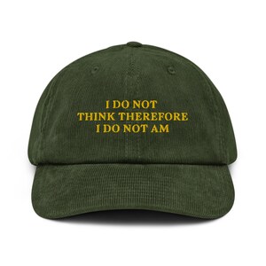 May include: A green corduroy baseball cap with the text "I DO NOT THINK THEREFORE I DO NOT AM" embroidered in yellow.