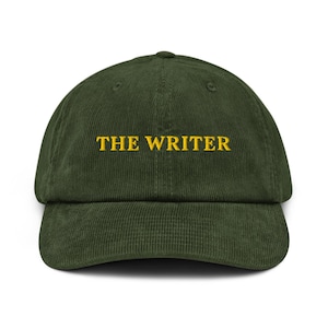 May include: A green corduroy baseball cap with the text "THE WRITER" embroidered in yellow.