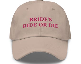 May include: A beige baseball cap with the text "BRIDE'S RIDE OR DIE" embroidered in pink.