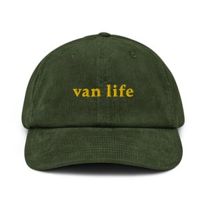 May include: A green corduroy baseball cap with the text "van life" embroidered in yellow.