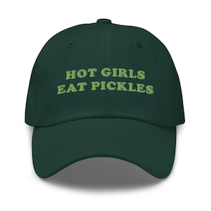 Op de afbeelding: Een donkergroene baseballcap met de geborduurde tekst "HOT GIRLS EAT PICKLES" in lichtgroen. De cap heeft een gebogen klep en een klassiek zes-panelen ontwerp.
