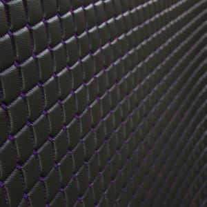 May include: Black leather upholstery with a diamond pattern stitched in purple thread.