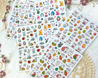 May include: Five sheets of Easter-themed nail art stickers. Each sheet features colorful illustrations of bunnies, Easter eggs, flowers, and the words "Happy Easter" and "Easter Day". The stickers are in various sizes and designs.