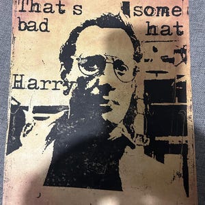 Könnte beinhalten: Ein Poster im Vintage-Stil mit Sepia-Ton zeigt ein Schwarz-Weiß-Bild eines Mannes mit Brille. Der Text "That's bad Harry, some hat" ist in einer Schreibmaschinenschrift gedruckt, was die Retro-Ästhetik unterstreicht.