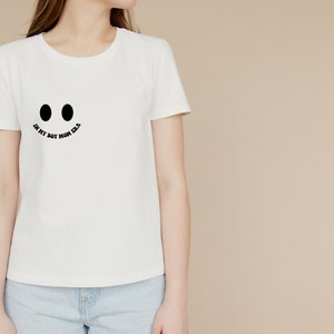 May include: White t-shirt with a black smiley face graphic and the text "In my boy mom era".