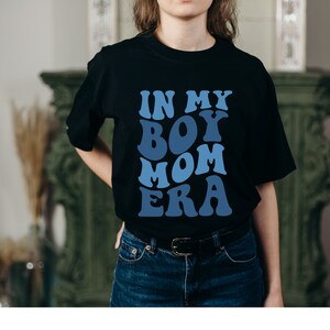 May include: Black t-shirt with a blue graphic that says "In My Boy Mom Era".