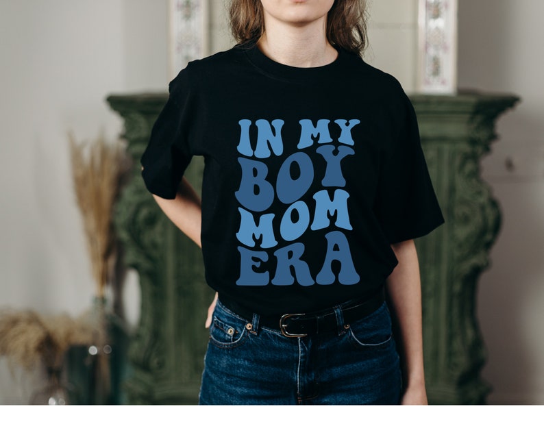 May include: Black t-shirt with a blue graphic that says "In My Boy Mom Era".