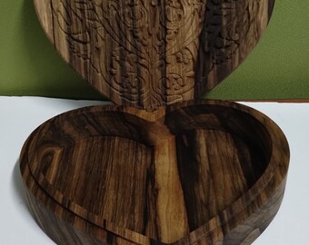 May include: A heart-shaped wooden box with a carved floral design on the lid. The box is open, revealing the empty interior.
