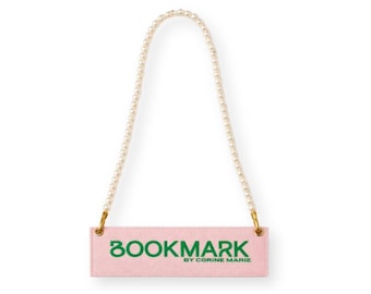 May include: A pink bookmark with the word "BOOKMARK" in green, and the text "BY CORINE MARIE". It has a pearl beaded handle with gold-colored metal attachments.