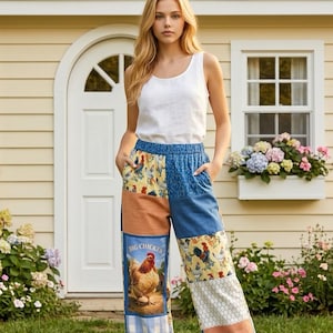May include: A woman wearing a white tank top and patchwork pants. The pants feature a variety of patterns, including denim, rooster prints, and a panel with a chicken illustration and the text "BIG CHICKEN".