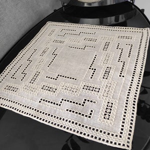 Peut inclure: Un chemin de table en lin beige avec un motif géométrique de broderie blanche. Le chemin de table a un bord festonné et est parfait pour ajouter une touche d'élégance à toute table.