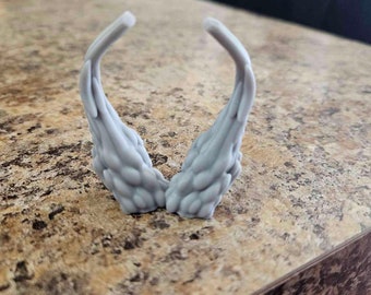 May include: A pair of gray 3D printed horns with a textured surface.