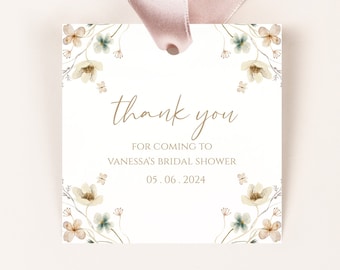 Puede incluir: Etiqueta de agradecimiento blanca con un borde floral. El texto dice "gracias" en escritura dorada, "por venir al baby shower de Vanessa" y "05.06.2024".