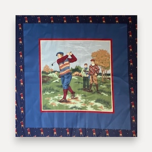 May include: A square fabric scarf featuring a central illustration of three golfers on a green course, framed by a blue border and a dark navy outer edge patterned with small repeating figures of golfers in red shirts and tan trousers.
