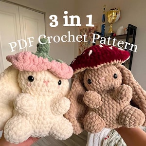 May include: Two plush crochet bunny toys, one cream-colored with a pink flower hat and the other tan with a red mushroom hat. The text "3 in 1 PDF Crochet Pattern" is displayed above the toys.