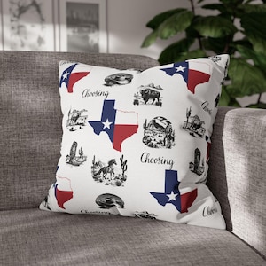 May include: A square throw pillow with a white background featuring a repeating pattern of the Texas state flag, black and white illustrations of cowboys, horses, bison, cacti, and cowboy boots, and the word Choosing printed in black script.