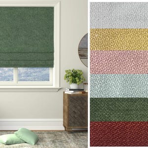 Puede incluir: Una estor romana verde con tejido texturizado. La estor está subida para mostrar la ventana detrás de ella. La imagen también muestra una variedad de otros colores y texturas de estores romanos.
