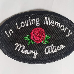 May include: Black oval embroidered patch with white text "In Loving Memory Mary Alice" and a red rose with green leaves.
