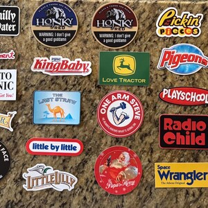 May include: A collection of various rectangular, circular, and die-cut vinyl stickers featuring diverse graphic designs, logos, and text including phrases like Chilly Water, Honky Shed, KingBaby, Love Tractor, Radio Child, and The Waker.