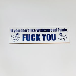 May include: A rectangular white bumper sticker featuring dark blue text that reads, "If you don't like Widespread Panic, FUCK YOU." The design includes two identical dark blue illustrations of a stylized, running stick figure character on each side.