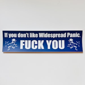 May include: A rectangular blue bumper sticker featuring white text that reads, If you don't like Widespread Panic, FUCK YOU. The design includes a white graphic of a stylized running figure on both the left and right sides of the text.